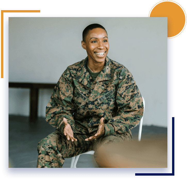 A man in military fatigues sitting on a chair.