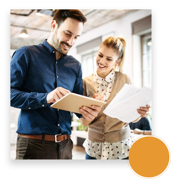 A man and woman looking at papers in an office.